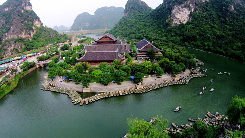 Grna berg och kanal med sm btar vid hotell Hidden Charm i staden Ninh Binh, Vietnam.